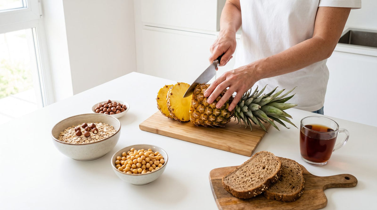 Ananas, Haferflocken mit Haselnüssen, Vollkornbrot, Kichererbsen und Tee auf einer Küchenarbeitsplatte: die wichtigsten Manganquellen im Alltag